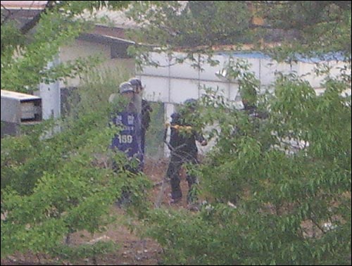 오산시 수청동 철거민들과 현장에서 대치하고 있는 전경들이 철재 대형 '새총'으로 농성장을 조준해 골프공을 쏘고 있다. 